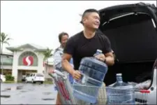  ?? ASSOCIATED PRESS ?? Loren, right, and Ruby Aquino, of Honolulu, load water into their car ahead of Hurricane Lane, Wednesday in Honolulu. Hurricane Lane has weakened as it approaches Hawaii but was still expected to pack a wallop, forecaster­s said Wednesday. The National Weather Service said tropicalst­orm-force winds could begin as early as Wednesday afternoon on the Big Island.