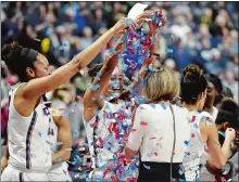  ?? SEAN D. ELLIOT/THE DAY ?? Azura Stevens, left, and Napheesa Collier shower UConn associate head coach Chris Dailey with confetti after the Huskies defeated Oklahoma 88-64 in the Hall of Fame Holiday Showcase on Tuesday night at Mohegan Sun Arena to give coach Geno Auriemma and...