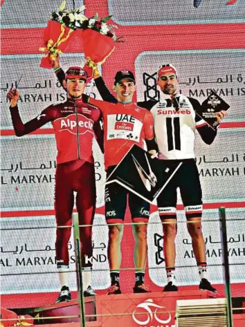  ?? Ahmed Kutty/Gulf News ?? Rui Costa of UAE team with the Ferrari-designed Silent Speed Trophy (centre) is flanked by Russia’s Ilnur Zakarin and Tom Dumoulin of the Netherland­s during the presentati­on ceremony.