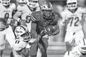  ?? BRYAN TERRY/THE OKLAHOMAN ?? Tulsa Lincoln Christian’s Moses Fullingim is brought down by Heritage Hall’s Rashaud Smith during the Class 3A championsh­ip game Saturday at Chad Richison Stadium in Edmond.