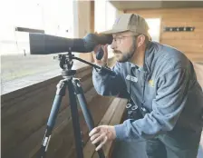  ?? JENNIFER BAIN ?? Joshua Wiese is the Crane Trust range manager. He looks for sandhill and whooping cranes from the VIP blind.