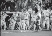  ?? The Associated Press ?? LEAVE IT TO BEAVER: Oregon State players, including Steven Kwan (4), celebrate after Adley Rutschman hit a double that scored Cadyn Grenier, right, Nick Madrigal and Jack Anderson during the eighth inning of the Beavers’ 11-6 win Wednesday against...