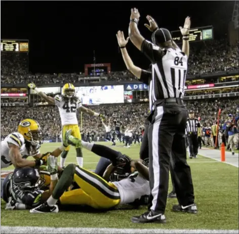  ??  ?? Officials signal touchdown after Seattle Seahawks’ wide receiver Golden Tate pulled in a last-second pass from quarterbac­k Russell Wilson to defeat the Green Bay Packers 14-12 on Monday night.
