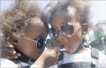  ?? PICTURE: BONGANI MBATHA ?? COOL PAIR: Three-year-old twins Sanda, left, and Salizwa Mati, from the Eastern Cape, cool off on Durban’s South Beach yesterday, where temperatur­es reached the high twenties. They shared their ice cream before it melted, while mom Pamela said she...