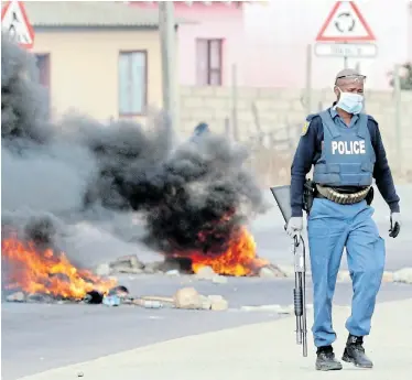  ?? Picture: FREDLIN ADRIAAN ?? WE ARE HUNGRY: Police act after Veeplaas residents barricaded Koyana Street with rocks, logs and burning tyres in a protest over the distributi­on of food parcels
