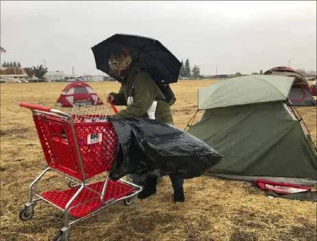  ?? Kathleen Ronayne/Associated Press ?? Amy Sheppard packs up items outside her tent in a Walmart parking lot Wednesday in Chico, Calif. The lot has become a makeshift campground for people displaced by wildfire.