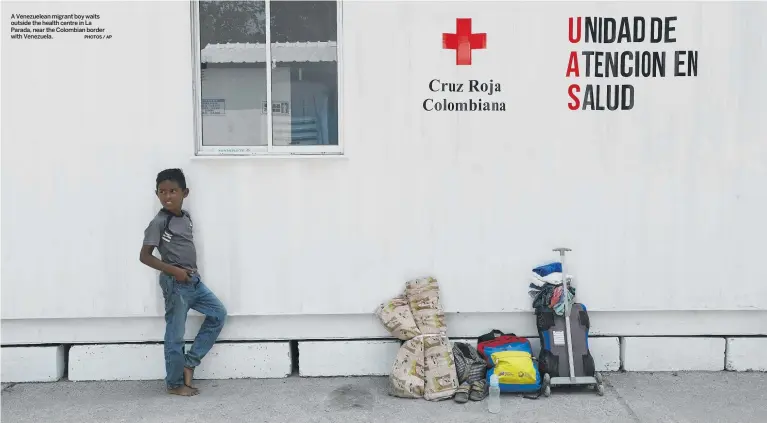  ?? PHOTOS / AP ?? A Venezuelea­n migrant boy waits outside the health centre in La Parada, near the Colombian border with Venezuela.