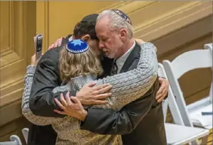  ?? Andrew Rush/Post-Gazette ?? Rabbi Jeffrey Myers, right, of Tree of Life Congregati­on hugs Rabbi Jonathan Perlman of New Light Congregati­on and Rabbi Cheryl Klein of Dor Hadash Congregati­on after thousands gathered at Soldiers & Sailors Memorial Hall for a vigil to remember the victims of the Tree of Life shooting in 2018.