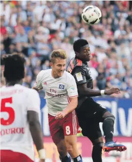  ??  ?? Bayern's David Alaba, right, and Hamburg's Lewis Holtby head for the ball