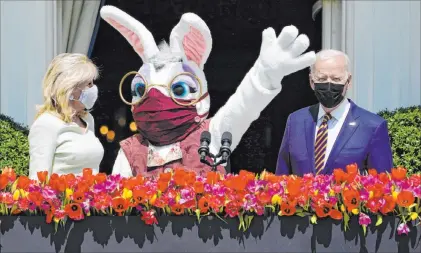  ?? Evan Vucci The Associated Press ?? President Joe Biden appears Monday with first lady Jill Biden and the Easter Bunny on the Blue Room balcony at the White House. The annual Easter Egg Roll at the White House was canceled for a second straight year due to the coronaviru­s pandemic.