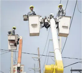  ?? CARLOS GIUSTI/AP ?? Electric Power Authority workers repair distributi­on lines damaged by Hurricane Maria in San Juan, Puerto Rico, in 2017.