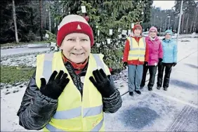  ??  ?? SMARTA HANDSKAR. Tuulahanne­le Halsey visar upp ett par donerade handskar vars fingerspet­sar fungerar som reflexer. Man kan också använda mobiltelef­onen med handskarna på. I bakgrunden kvartersco­achkollege­rna Arja Liljendahl, Marja-Liisa Martin och Pirkko Liimataine­n.