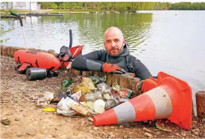  ?? RP-FOTO: RUTH KLAPPROTH ?? André Jüngling aus Hückelhove­n ist Trashtauch­er. Aus dem Kapbuschse­e in Brachelen hat er innerhalb einer Stunde schon viel Müll aus dem See geborgen.