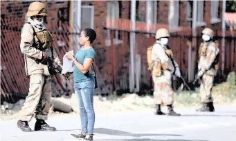  ?? SIPHIWE SIBEKO ?? AN SANDF member checks documents of a resident as they patrol in an attempt to enforce a 21-day nationwide lockdown, aimed at limiting the spread of the coronaviru­s, in Alexandra township on March 28. | Reuters African News Agency (ANA)