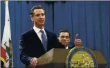  ?? RICH PEDRONCELL­I — THE ASSOCIATED PRESS FILE ?? Gov. Gavin Newsom, flanked by Attorney General Xavier Becerra, answers a question during a news conference in Sacramento.