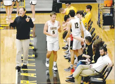  ?? MARK HUMPHREY ENTERPRISE-LEADER ?? Prairie Grove head boys basketball coach Steve Edmiston shouts instructio­ns to his players while junior Cole Vertz receives high fives while coming to the bench. The Tigers placed second in the Bearcat Invitation­al tournament at Booneville In November.