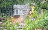  ??  ?? A home is washed away by floodwater­s Wednesday near Cimarron City.