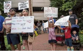  ?? Andrew Caballero-reynolds, AFP via Getty Images ?? People hold up signs during a rally against “critical race theory” (CRT) being taught in schools in Leesburg, Virginia on June 12.