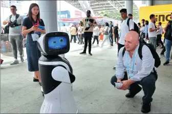  ?? SHI LEI / FOR CHINA DAILY ?? A buyer from abroad interacts with a robot made in Guangdong province at the Canton Fair being held in Guangzhou, Guangdong province.