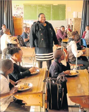  ?? Picture: MIKE HOLMES ?? SHORT-HANDED: Kleinpoort Primary School principal-teacher Roseline Mthwalo in a multiple-grade classroom as the pupils enjoy a meal