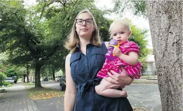  ?? PHOTOS: ARLEN REDEKOP ?? Sheila Louis, with daughter Annabelle, is frustrated at the city’s response to her complaints about aphids from a tulip tree near her property. She says the insects’ sticky secretions coat her house, driveway and family car.