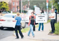  ?? CLOE POISSON/SPECIAL TO THE COURANT ?? Protesters hold signs at a rally against a vaccine requiremen­t for Hartford Healthcare employees outside Hartford Hospital on Saturday.