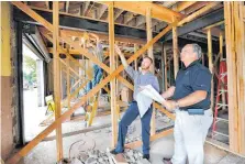  ?? [PHOTO BY JIM BECKEL, THE OKLAHOMAN] ?? Branson Young and Kevin Williams survey progress of renovation­s on the first floor of the Morgan Building. Working on a steel beam in the background is Ethan Watson. This building at 600 NE 4, formerly an office for a black physician, is being...