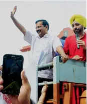  ?? — PTI ?? Delhi chief minister Arvind Kejriwal ( left) gestures to his supporters as he addresses them before appearing in court for the hearing of a defamation case filed against him in Amritsar on Friday. Punjab minister Bikram Singh Majithia ( right) comes...