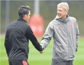  ??  ?? Mesut Ozil shakes hands with Gunners boss Arsene Wenger.