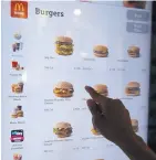  ?? CHARLES REX ARBOGAST/ASSOCIATED PRESS ?? A customer orders food using a touchscree­n at a self-service kiosk at a McDonald’s in Chicago.