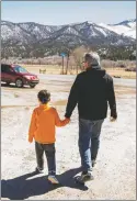  ?? ?? Danny Taylor, 7, holds his father’s hand as they run errands in Questa, the village where the Ukrainian-American family has found refuge from war. ‘I need a job, I need a place to stay, I need a car, I need a little bit of cash to make it all work,’ said Taylor. ‘We got here, and we had no money, no clothes — nothing.’ As for Lidia, ‘she’s got a 30-day tourist visa, then we have to figure it out from there.’