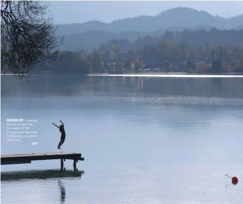  ?? — AFP ?? A young woman jumps into the water of the Forggensee lake near Schwangau, southern Germany.