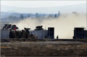  ?? MEHMET GUZEL — THE ASSOCIATED PRESS ?? In this photo taken from the outskirts of the village of Mert Ismail near the town of Suruc, southeaste­rn Turkey, Turkish army vehicles return to Tirley from Syrian after conducting a joint patrol with Russian forces, Tuesday. Turkey and Russia launched joint patrols for the second time in northeaste­rn Syria, under a deal that halted a Turkish offensive against Syrian Kurdish fighters who were forced to withdraw from the border area following Ankara’s incursion.