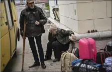  ?? ARIS MESSINIS — AFP VIA GETTY IMAGES ?? Residents sit with their belongings as they wait to be evacuated from the city of Lysychansk, eastern Ukraine, on Friday.