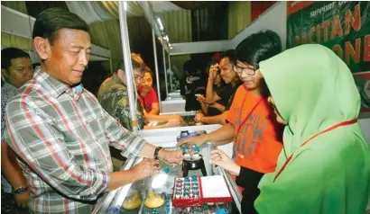  ?? M. ALI/JAWA POS ?? TELITI: Jenderal TNI (pur) Wiranto sedang memeriksa kualitas batu bacan di pameran Batu Nusantara Show and Contest di BSD, Tangerang Selatan. Kini Abami yang dibina mantan panglima TNI itu sedang menggodok aturan yang menstandar­kan harga batu akik.