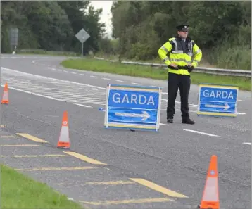  ??  ?? A Garda diverts traffic at the scene between Ferrycarri­g and Kyle Cross.