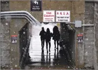  ?? Canadian Press photo ?? From Toronto, where ice storms cancelled baseball games, to Calgary where residents this week faced yet another heavy snowfall warning, April 2018 has come to feel like endless winter. Students walk under the O-Train tracks as snow falls on Carleton...