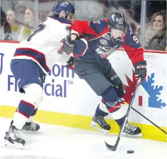  ?? NICK BRANCACCIO ?? Windsor Spitfires Jean-Luc Foudy slips away from Saginaw Spirit Reilly Webb, in OHL action from WFCU Centre on Thursday. Webb drew a penalty on the play.