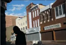  ?? AP PHOTO/PATRICK SEMANSKY ?? A man walks past vacant storefront­s at the Old Town Mall in Baltimore. Job growth was supposed to be a cure-all to stop the wealth gap from worsening, but new research suggests that impoverish­ed Americans are getting left out even when their communitie­s enjoy hiring booms.