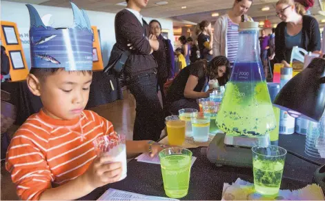  ?? Bay Area Science Festival ?? A youngster wearing a paper crown of shark fins visits an S.F. State booth on chemistry and colors.