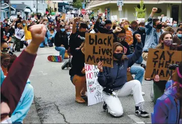  ?? PHOTOS BY SHMUEL THALER — SANTA CRUZ SENTINEL ?? Black Lives Matter protesters take a knee on Capitola Avenue in front of the Capitola Police Department during a march and rally Wednesday.