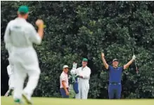  ?? AP PHOTO/ MATT SLOCUM ?? Rickie Fowler, left in pink, watches as Jon Rahm, in blue, celebrates his hole-in-one during a practice round Tuesday at Augusta National Golf Club in preparatio­n for the Masters, which is being held in November for the first time. The tournament tees off today in Georgia.