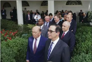  ?? AP/PABLO MARTINEZ MONSIVAIS ?? Commerce Secretary Wilbur Ross (left) and Treasury Secretary Steven Mnuchin watch with others Wednesday in the White House Rose Garden as President Donald Trump and European Commission President Jean-Claude Juncker discuss their meeting on trade policy.