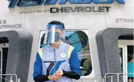  ??  ?? A cast member dons a face shield and mask at Test Track during the reopening day of Epcot on Wednesday.