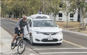  ?? JULIA WANG/WAYMO VIA THE ASSOCIATED PRESS ?? A Chrysler Pacifica minivan using Waymo’s self-driving car technology is tested in proximity to a company employee on a bicycle at Waymo’s facility in Atwater, Calif.