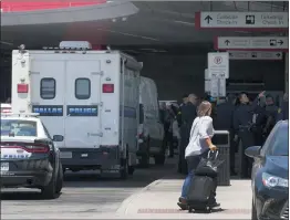  ?? TONY GUTIERREZ — THE ASSOCIATED PRESS ?? A traveler makes her way past emergency responders standing outside the ticketing and check in area at Dallas Love Field in Dallas on Monday.