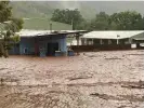  ?? Photograph: Kylie Hanslow ?? Flood waters rage in the remote Aboriginal community of Wujal Wujal after days of rain.