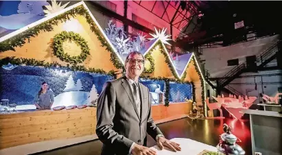  ?? RP-FOTOS (2): ANDREAS ENDERMANN ?? Der Chef von Düsseldorf Tourismus, Frank Schrader, bei der Premiere der aufgehübsc­hten Hütten für den Weihnachts­markt auf dem Schadowpla­tz. Die Holzschnit­te auf dem Dach zeigen Motive und Figuren aus Grimms Märchen.