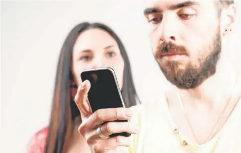  ?? // ABC ?? Un hombre utiliza el teléfono móvil ante la atenta mirada de una mujer