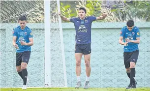  ??  ?? Belgium-based goalkeeper Kawin Thamsatcha­nan, centre, trains with the national team.